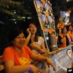 香港市民李小姐(左一)替區議會選舉候選人助選
