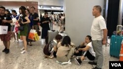 有旅客在西九高鐵站大堂席地而坐吃瓜子。(美國之音湯惠芸拍攝)