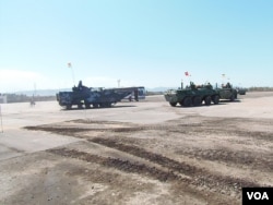 去年8月里海岸边的军事比赛活动中，中国海军陆战队的两栖登陆战车（左）与俄罗斯装甲车。