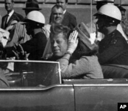 肯尼迪总统及其夫人杰奎林1963年11月22日坐在一辆敞篷车上在达拉斯行驶，几分钟后肯尼迪总统遇刺