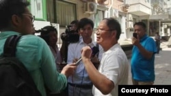 炎黄春秋杂志社负责人胡德华在被强占的办公地点外面接受外媒采访。（网友提供）