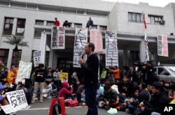 3月20日台湾立法院外一位教授对学生讲话。有标语说“逐一审查服贸条款”