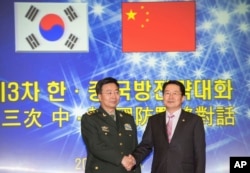 韩国国防部次官白承周（右）与中国人民解放军副总参谋长王冠中在首尔参加第三次韩中国防战略对话。（2013年11月28日）