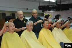 佔中發起人戴耀廷(後排左二)替政治漫畫家尊子（前排左二）剃頭。（美國之音湯惠芸攝）