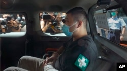 香港首位被控涉嫌違反國安法的男子唐英傑（Tong Ying-kit）坐著輪椅由警車押解至法院應訊。（2020年7月6日）