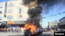 2023年10月7日，在加沙地帶北部，一名巴勒斯坦男孩在一輛燃燒的以色列車輛旁邊做出反應，這輛車輛是巴勒斯坦槍手滲透到以色列南部地區後帶到加沙的。（路透社）