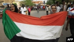 蘇丹婦女2019年6月30日在首都喀土穆的集會上舉著國旗遊行。