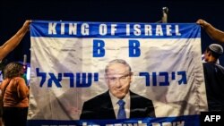 Right-wing demonstrators hold a banner showing an image of Israel's Prime Minister Benjamin Netanyahu during a rally in support of his government's planned judicial overhaul outside the Supreme Court in Jerusalem on Sept. 7, 2023.