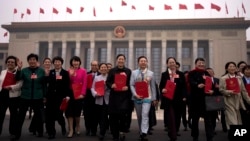 2025年3月11日出席全國人民大會閉幕式後，手持全國人民代表大會報告的代表離開人民大會堂。