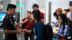 3月9日马里西亚警察在吉隆坡的国际机场检查旅客的身份证明