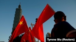 资料照：一些支持中国的台湾人在台北101大楼前举着中国国旗。(该照片拍摄时间为2016年8月22日，路透社提供)
