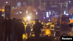 槍擊事件後，專業人員聚集在番紅花市政廳附近的死難者旁。(2024年3月22日)