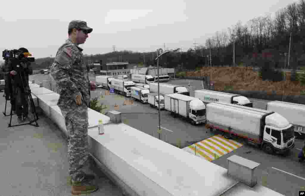 S2013年3月28日，韩国的汽车从朝鲜开城联合工业园区返回韩国境内。美国陆军士兵在非军事区附近的海关、移民和检疫处关注着入境车辆。