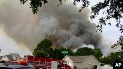 ເຈົ້າໜ້າທີ່ເຮັດວຽກເພື່ອຄວບຄຸມໄຟປ່າໃນເຂດປ່າ ຄາໂຣໄລນາ , ທາງທິດຕາເວັນຕົກຂອງເມືອງຣີສອດແຄມຝັ່ງທະເລຂອງ ມີເທີລ ບິສ ລັດຄາໂຣໄລນາ ໃຕ້ ວັນທີ 2 ມີນາ 2025 WMBF-TV ຜ່ານ AP 