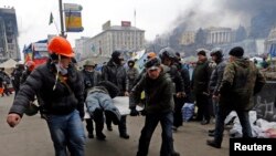 烏克蘭示威者在星期四與警察衝突後將傷者抬離現場