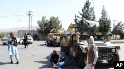 在喀布爾機場外面警戒的塔利班武裝人員。