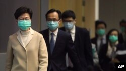戴著口罩的香港特首林鄭月娥帶領港府官員步入一個新聞發布會會場。 （2020年1月31日）