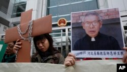 香港天主教徒舉著師恩祥主教的肖像在中聯辦附近示威（2010年12月7日）香港天主教徒举着师恩祥主教的肖像在中联办附近示威（2010年12月7日）