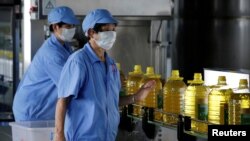資料圖片：2018年7月4日，中國一工廠工人用美國大豆提煉生產瓶裝豆油。
