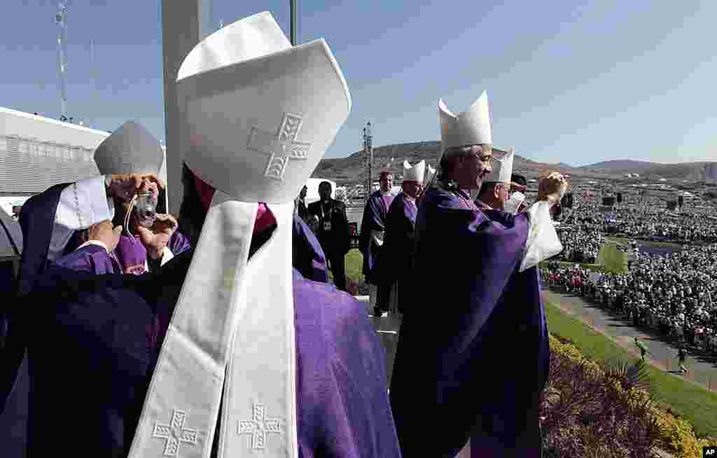 Prelates take pictures of each other and the crowd of faithful gathered at the Parque del Bicentenario as they wait for the arrival of Pope Benedict for a Mass near Silao, Mexico, March 25, 2012. (AP)