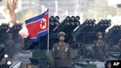 ທະ​ຫານ ເກົາຫຼີ​ເໜືອ ຢືນ​ຢູ່​ລົດ​ຫຸ້ມ​ເກາະຕິດ​ເຄື່ອງ​ຍິງ​ຈະຫຼວດ​ໃນ​ຂະ​ນະ​ທີ່​ພວກ​ເຂົາ​ເດີນ​ສວນ​ສະ​ໜາມ​ໃນ​ນະ​ຄອນຫຼວງ ພຽງ​ຢາງ, ເກົາຫຼີ​ເໜືອ, 10 ຕຸ​ລາ 2015.(AP Photo/Wong Maye-E, File)