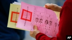 一位台灣民眾2016年1月16日在台北一投票站準備填寫手中的選票