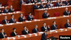 ປະ​ທານ​ປະ​ເທດ ສີ ຈິ່ນ​ຜິງ ແລະ ເຈົ້າ​ໜ້າ​ທີ່​ຄົນ​ອື່ນໆ​ຕົບ​ມື​ໃຫ້ນາ​ຍົກ​ລັດ​ຖະ​ມົນ​ຕີ ທ່ານ ຫຼີ ຈຽງ ໃນ​ການ​ກ່າວ​ສະຫຼຸ​ບ​ວຽກ​ງານ​ຂອງ​ທ່ານ, ຫໍ​ປະ​ຊຸມ​ໃຫຍ່​ແຫ່ງ​ປະ​ຊາ​ຊົນ ຈີນ, ປັກ​ກິ່ງ, ຈີນ, 5 ມີ​ນາ 2025. REUTERS/Florence Lo