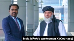 از راست به چپ: نورالدین عزیزی، وزیر تجارت و صنعت طالبان و آنند پرکاش، دستیار وزیر خارجۀ هند در امور پاکستان، افغانستان و ایران