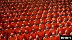 2021 年 9 月 9 日在平壤金日成广场举行的朝鲜国庆73周年的检阅仪式上穿着橙色防护服的人员在行进。（路透社）