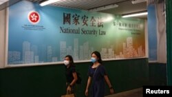 行人走過香港政府在街頭張貼的港版國安法宣傳標語。 （2020年6月29日）