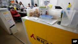 ໃນ​ພາບ​ນີ້​ທີ່​ຖືກ​ຖ່າຍ​ໃນ​ວັນ​ທີ 8 ທັນ​ວາ 2015, ພະ​ນັກ​ງານ​ສະ​ມາ​ຄົມ​ອົ​ບ​ພະ​ຍົບ ຍີ່​ປຸ່ນ ເຮັດ​ວຽກ​ຢູ່​ຫ້ອງ​ການ​ຂອງ​ເຂົາ​ເຈົ້າ​ໃນ​ນະ​ຄອນຫຼວງ ໂຕ​ກຽວ.