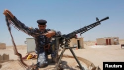 伊拉克軍人在巴格達以南調整子彈帶