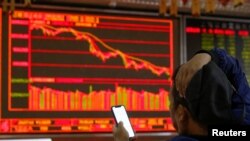 一名中國投資者坐在北京一個證券交易所的電子顯示屏前。（2018年10月11日）