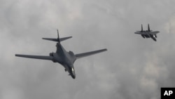 2017年6月30日，南韓國防部圖片顯示美國空軍B-1B槍騎兵型轟炸機（左）和南韓F-15K戰鬥機在朝鮮半島上空飛行（2017年6月30日）
