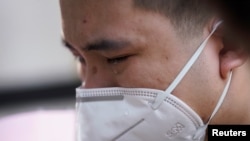 中國為死于冠狀病毒病(COVID-19)的人舉行全國哀悼活動，湖北省武漢市一名戴著口罩的男子哭泣。 （2020年4月4日）