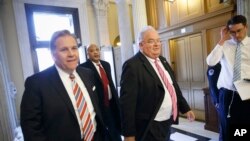 美国国会议员，来自密西根的共和党人麦克尔.罗杰斯（左）12月4日和其他议员一道进入国会大厦投票。 