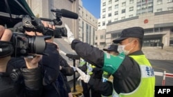 一名警察擋住記者的鏡頭阻止拍攝審訊公民記者張展的上海浦東新區法院外景。 （2021年12月28日）