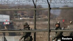 韓國陸軍士兵2013年４月８日在坡州沿著靠近板門店村邊界附近的鐵絲網巡邏。