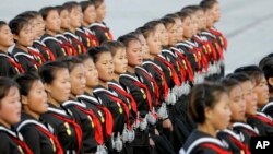 2015年10月10日，北韓少女肩上掛著手榴彈模型在平壤遊行。2017年9月的美國新政令禁止北韓等八國公民進美國