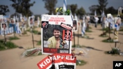 资料照片：显示以色列-美国籍人质赫什·戈德伯格-波林的海报树立在以色列南部的加沙边界。(2024年4月25日) 