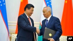 習近平今年9月訪問烏茲別克斯坦時和東道國總統卡里莫夫握手。