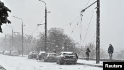 2024年1月8日，调查人员在乌克兰扎波罗热俄罗斯导弹袭击现场的受损汽车旁工作。（路透社照片）