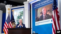 拜登總統在白宮大院內的艾森豪威爾行政大樓南院禮堂參加白宮新冠疫情響應團隊與全國州長協會的定期電話會議。視頻中顯示的是阿肯色州的州長哈欽森。(2021年12月27日)