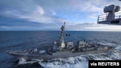 美國海軍"基德號"導彈驅逐艦在阿拉斯加灣參加演習時與"西奧多·羅斯福號”航空母艦並肩行駛。(2018年5月16日)
