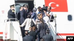 9月20日，土耳其總理達烏特奧盧（左二）和被釋放人質步下飛機。