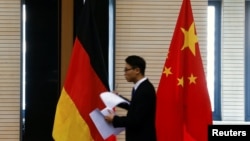 資料照：在北京舉行中德經貿部長會議期間一名男子走過中國和德國國旗。 （2016年11月1日）