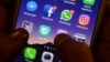 FILE - This photo taken March 22, 2018, shows apps for WhatsApp, Facebook, Instagram and other social networks on a smartphone.