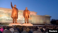 北韓人在金正日及其父親金日成的雕像前鞠躬和獻花的場面。