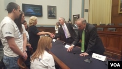 國會眾議院移民與邊境安全小組委員會主席、共和黨議員高迪(Rep. Trey Gowdy)與非法移民犯罪的受害者家屬羅拉威爾克森握手，共和黨議員史蒂芬.金（Rep. Steve King）與另一位家屬米歇爾如特交談。（美國之音魏之拍攝）