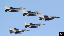 台湾空军的F-16战机编队从台南空军基地上空飞过。（2014年1月16日）